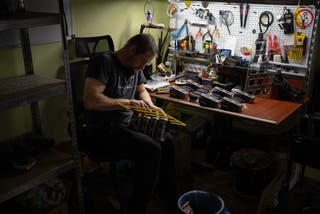 A soldier from the drone battalion of the 225th Ukrainian Separate Assault Regiment fighting near the Russian border in the Kursk region, assembles modified drone components in an undisclosed location